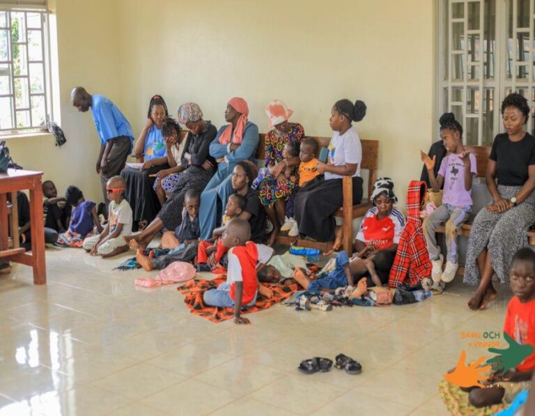 Beneficiary families gather indoors for the community session.