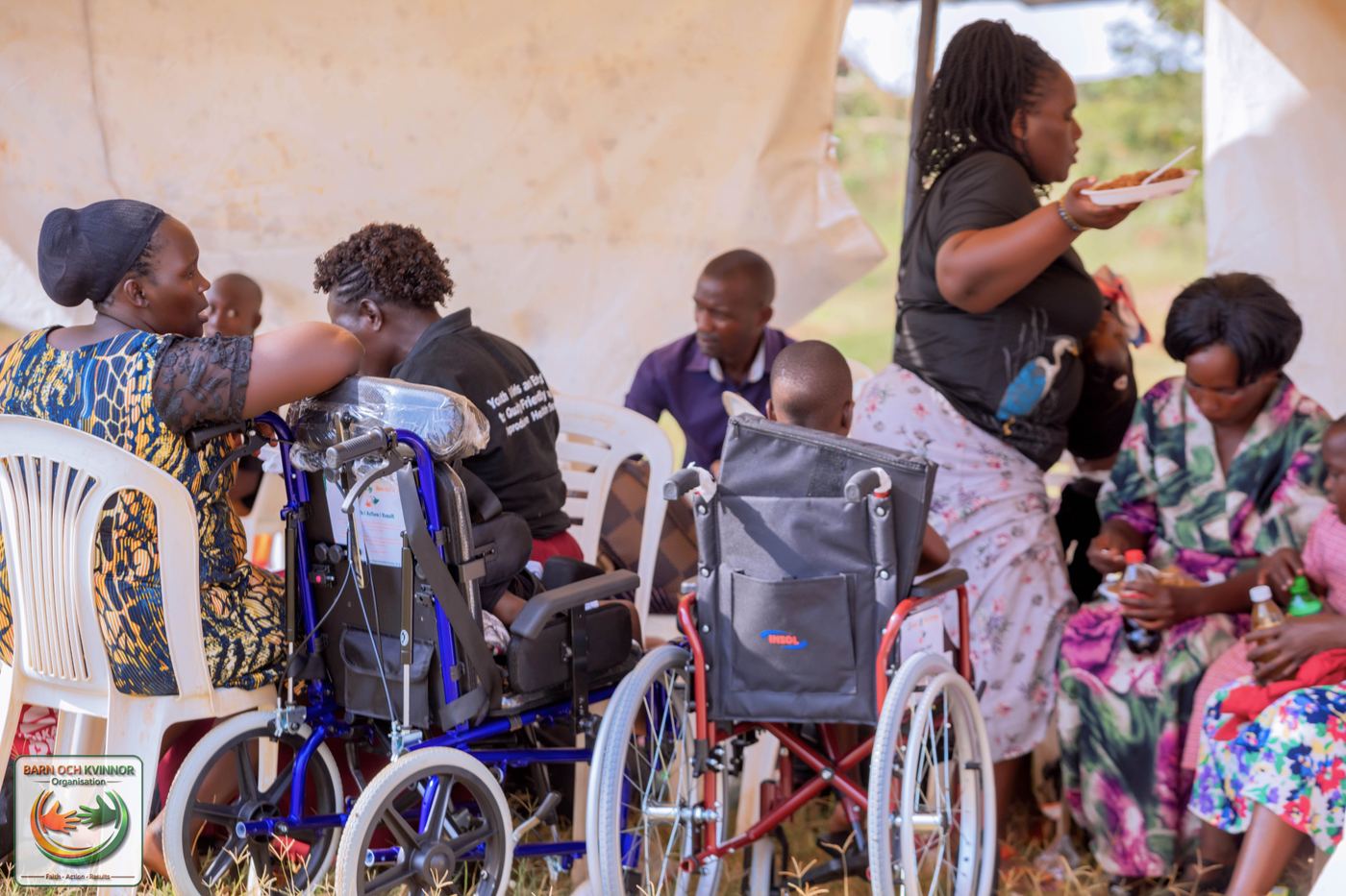 Children rest in their wheelchairs while sharing a meal.