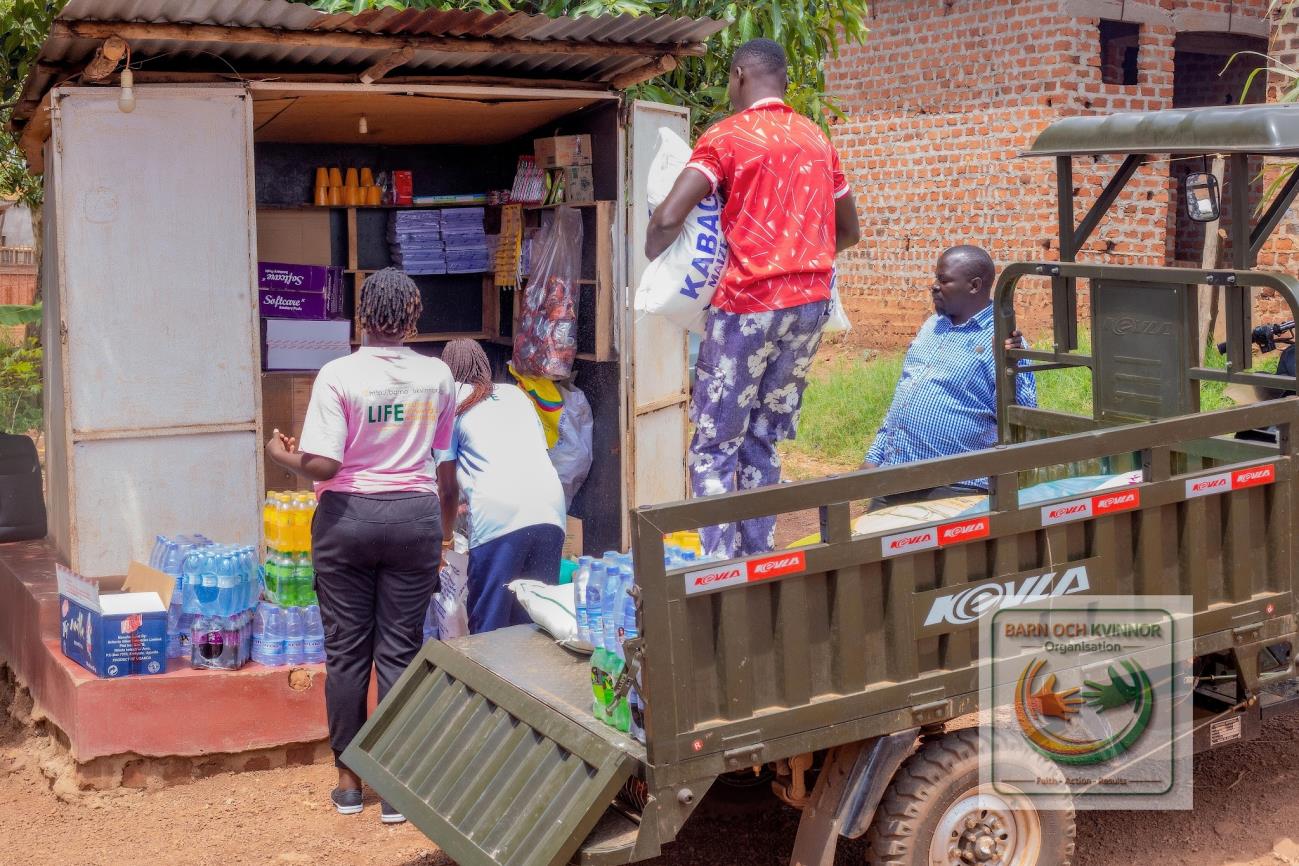 Team members and a mother loading start-up stock into a new kiosk