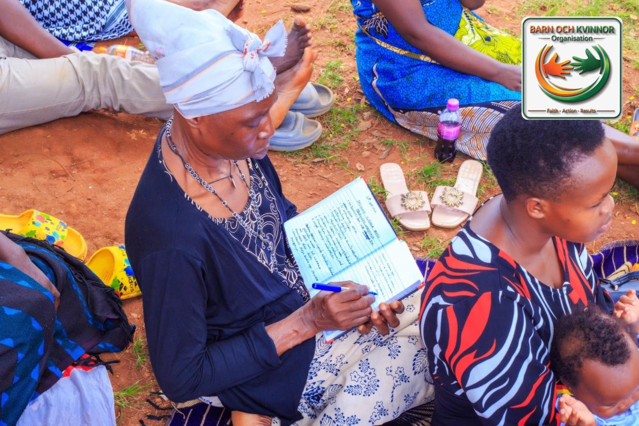 A woman writing in her notebook during financial literacy training